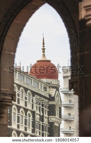 A picture of Taj Hotel's dome shot from between the pillars of Gateway of India