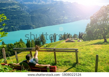 Traveler Man relaxing meditation with serene view mountains and lake landscape Travel Lifestyle hiking concept summer vacations outdoor. Landscape view of a summer day with a tourist in the mountains