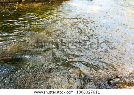Water texture. Mountain river. Waves of green, blue and gray. Calm and tranquility. Nature. A park. Stones on the river bank. Rapid flow of water Royalty-Free Stock Photo #1808027611