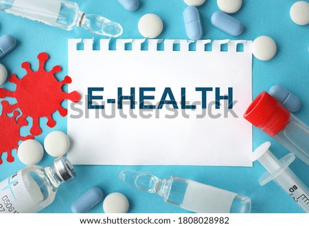 e-health. text on white paper on blue background near multicolored pills of syringe ampoules of sign coronavirus