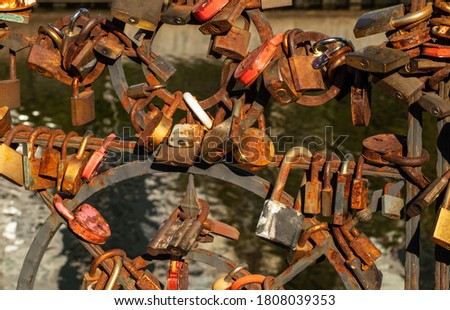 Many rusty locks on the railings of a bridge