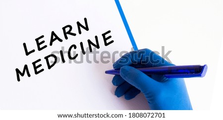 Female doctor's hand in a medical glove makes an inscription in a document.