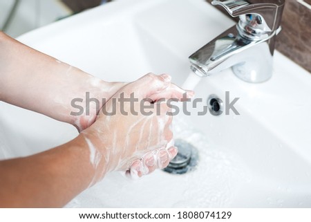 Hygiene concept. Washing hands with soap under the faucet with water