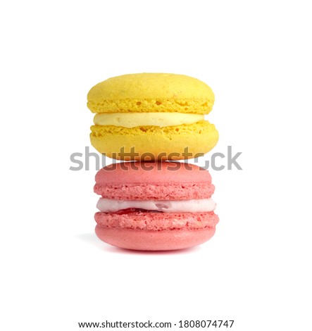 pink and yellow round baked macarons isolated on a white background, close up