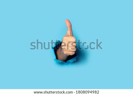 Male hand makes a hand up gesture on a blue background. Banner. Gesture all ok, like