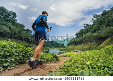 Runner running a trail. In the mountain.Picture from the back