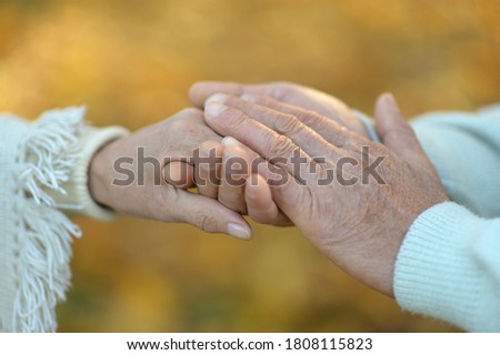 Hands of senior couple, cropped on background