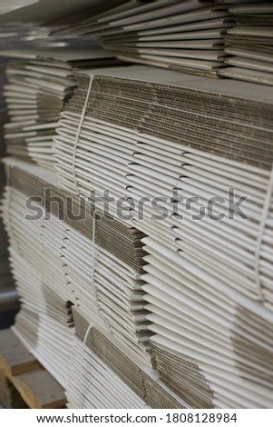 Corrugated cardboard sheets are one by one, they are prepared for the production of cardboard boxes. Polygraphic background of cardboard