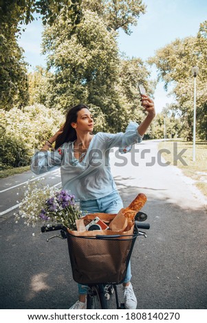 Stylish woman riding a bicycle and using a cellphone.