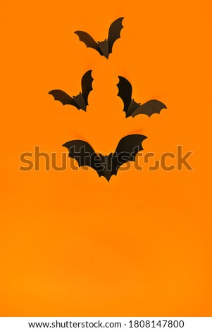 Cartoon Halloween background black bats on orange backdrop. Bright holiday backdrop for your design. Dark and moody background. Place for text.