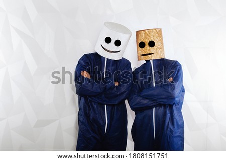 Two people in a marshmallow man suit stand against a white structural background. This is the best way to promote a company's brand.