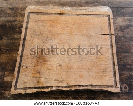 Rustic wooden chopping board on a wooden surface