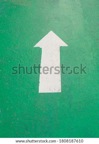 The white arrow on green background At the bicycle lane in the park
