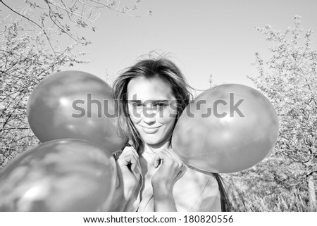 Portrait of Young Beautiful birthday latin hispanic girl with colorful balloons on blue cloudy sky background Copy space for inscription closes his eyes with his hands