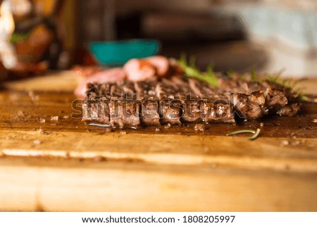 family barbecue beautiful beef cuts on a wooden board with a touch of excellent rosemary combination