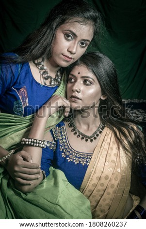 Indian brunette female model poses for pictures  with her sister at their home during lock down.