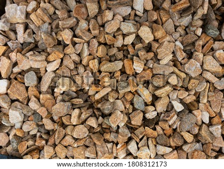 Stone chips from natural sandstone and goldstone. Background from orange and brown stones. Texture of small stones. Zlotolite for garden paths, flower beds and borders Royalty-Free Stock Photo #1808312173