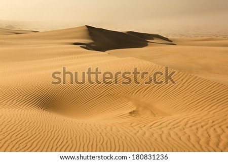 australia dry desert sand dune in NSW day time with dust storm approaching over waves of lifeless sand