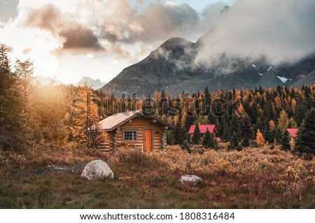 Wooden huts with sunshine in autumn forest at Assiniboine provincial park, Canada Royalty-Free Stock Photo #1808316484