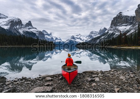 Traveler sitting with paddle on canoe in Maligne lake at Spirit Island, Jasper national park, Canada Royalty-Free Stock Photo #1808316505