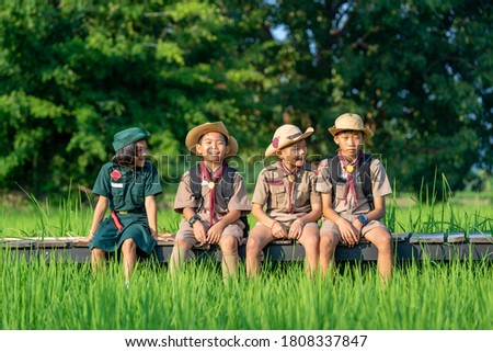 America boy scouts in uniform sitting in green field on a sunny day while,Summer camp.