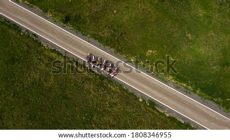 Motorbikes driving through the road, that leads on diagonal of the picture. Aerial view. Copy space
