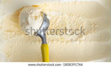 Close up Vanilla ice cream scooped out from container with a spoon, Food concept.