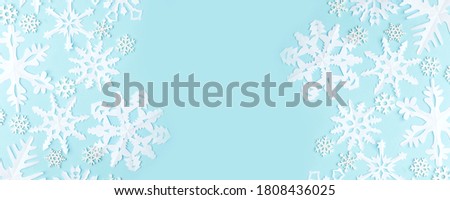 Winter pattern made of papercraft snowflakes on blue background. Winter concept. Flat lay. Tender concept of seasonal holiday, childrens creative activities, xmas, Christmas, New Year flyer