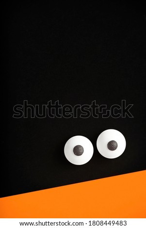 Halloween background, pair of eyes on black and orange