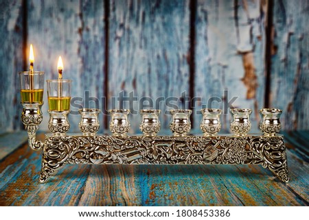 Lighting the first candle on a hanukkah of a burning Chanukah candlestick with candles Menorah a traditional Jewish holiday