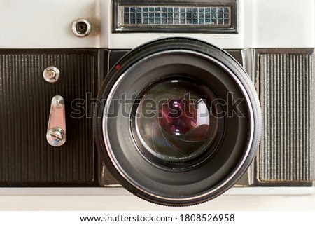 Vintage photo camera with optical lens and aperture blades, front view as icon. Old retro devices backgrounds