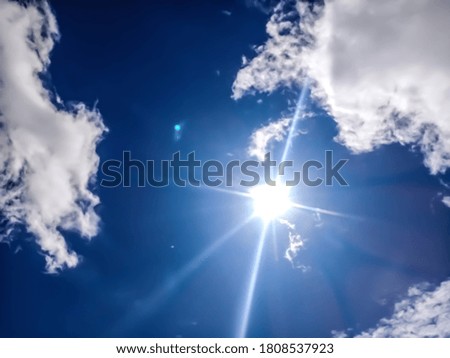 A beautiful picture of shining sun, blue sky and clouds. 