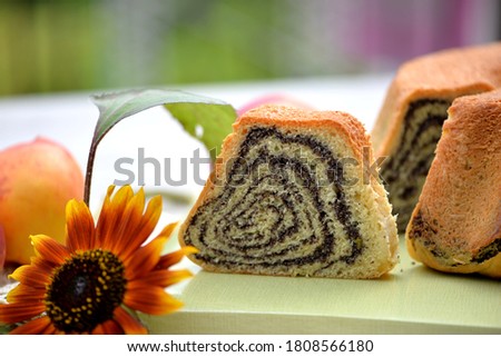 Bread texture of home baked Slovenian potica / poppy seeds roll with sunflower in background