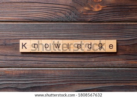 Knowledge word written on wood block. Knowledge text on cement table for your desing, concept.