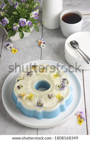 Puding bunga. Edible flower pudding. On the top side, clear pudding with edible flower, Middle part is milk flavor and the bottom side is butterfly pea flavor.