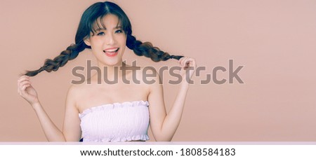 Beautiful young asian woman with healthy&clean skin on pink tone background remain blank space for cosmetic product advertising