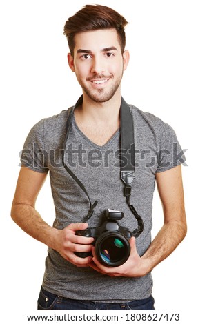 Young smiling man holds a camera with radio trigger as a photographer