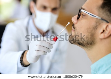 Close-up of young man getting PCR test at doctor's office during coronavirus epidemic.  Royalty-Free Stock Photo #1808630479