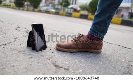 blue jeans with brown casual shoes standing beside phone and wallet