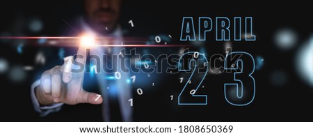april 23rd. Day 23 of month, advertising or high-tech calendar, man in suit presses bright virtual button spring month, day of the year concept.