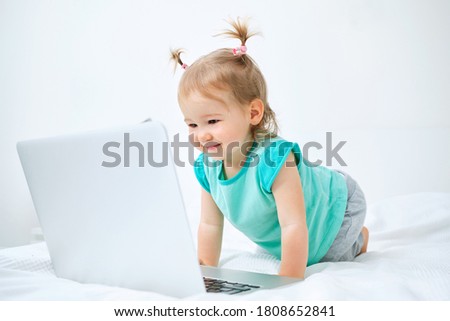 Caucasian kid sitting on bed and watching cartoons.