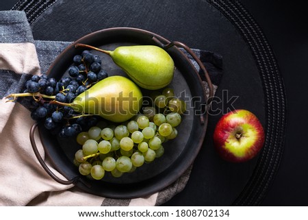 Still life fruit concept pear and grape in vintage iron tray with copy space
