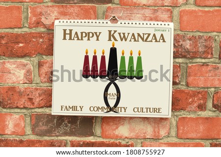 Happy Kwanzaa Day 7 Imani (African Faith) Kinara (Candle Holder) Calendar hanging on brick wall