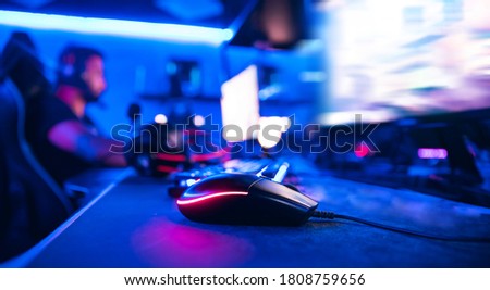 Gaming mouse and keyboard for professional esportsman in neon flowers, soft focus.