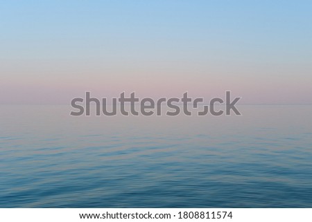 Blue and purple gradient of the sky and sea in the evening. Calm sea wavy surface Royalty-Free Stock Photo #1808811574