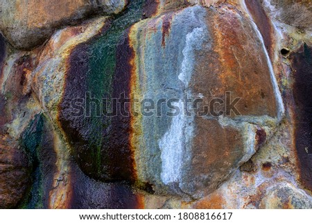 Colorful stone surface closeup photo with wet stain. Stone wall texture for natural rustic background. Big rocks with water, moss and rust. Geology backdrop. Dirty water stain. Grungy stone wall