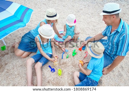 Happy family playing by the sea shore on the sand background