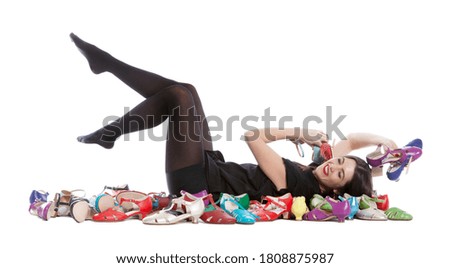 Young woman isolated on white background having a lot of shoes with many sizes and colors.