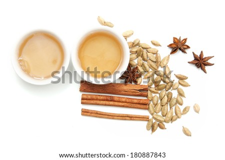 Cardamom, star anise, cinnamon and two cups of tea on a white background Royalty-Free Stock Photo #180887843