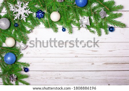 Fir branches with blue and silver Christmas decor on a light rustic background. Copy space. New Year card. Christmas concept